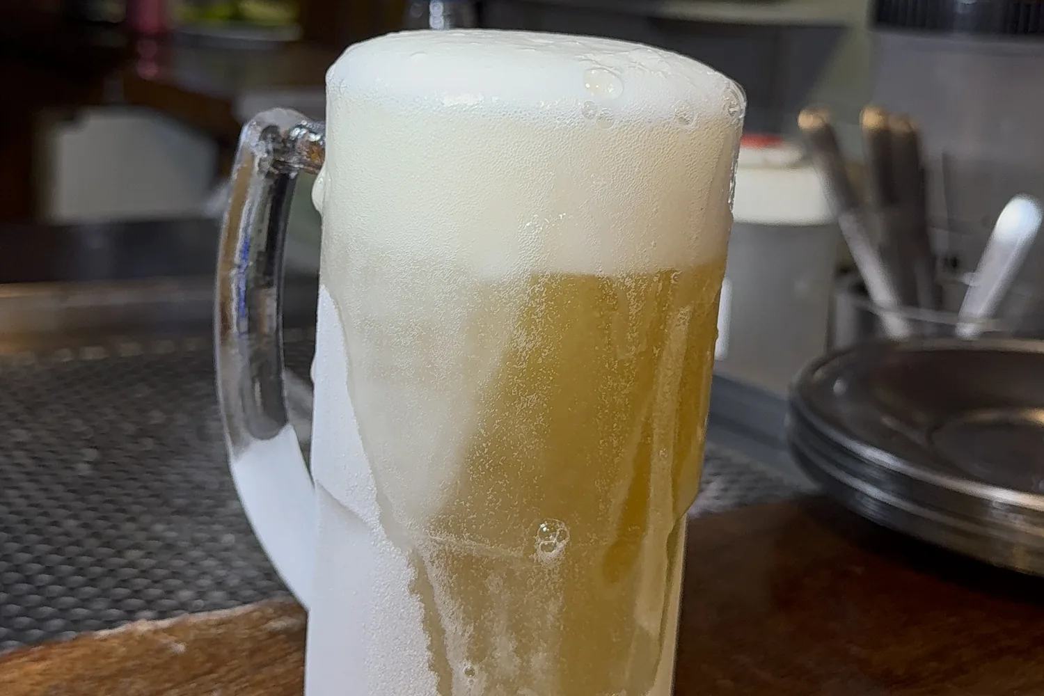 A mug of ice-cold draft beer at Hera, the glass covered in frost