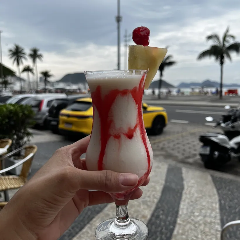 A drink served at Hera with the Copacabana beachfront behind