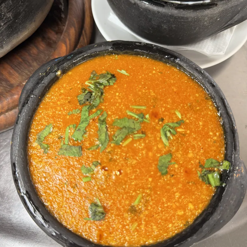 Hera's capixaba moqueca seen from above, in the clay pot