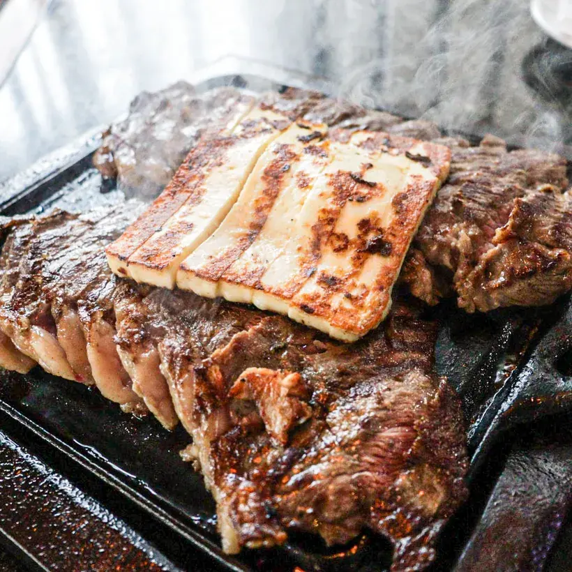 Picanha à Daniel on the grill with grilled coalho cheese on top