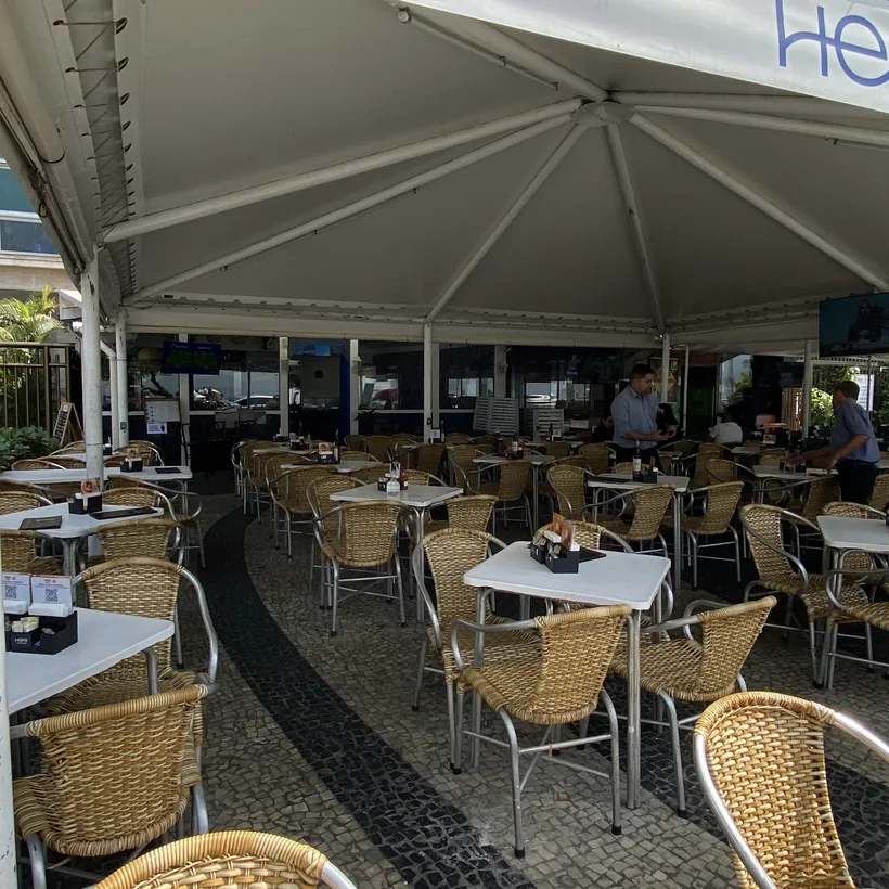 Hera's dining room full of tables under the awning, seen from the entrance