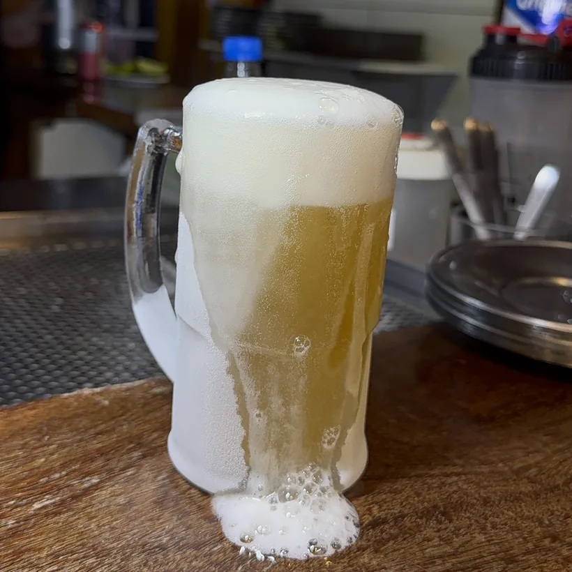 Draft beer overflowing with foam