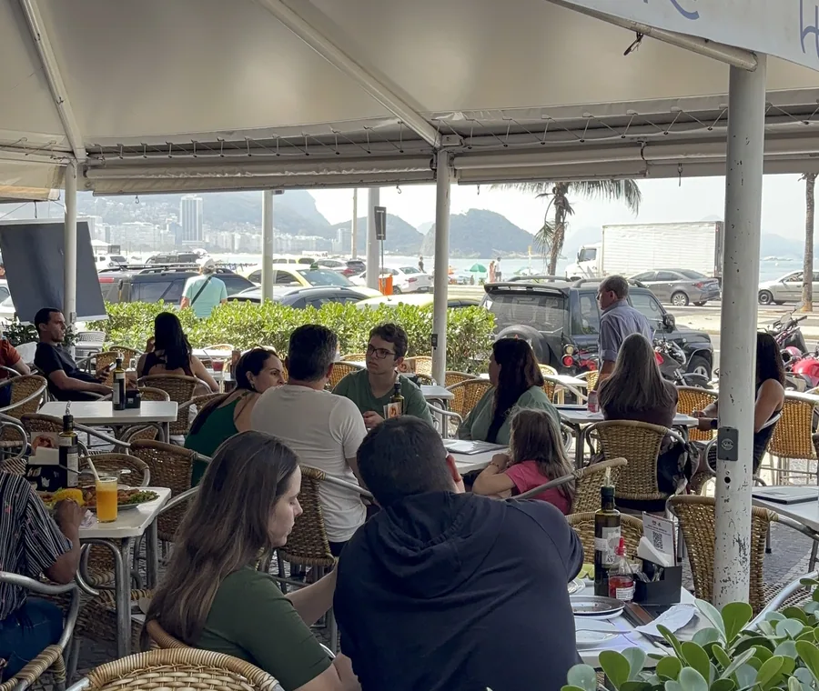 Hera Bar e Botequim's dining room, full, under the sidewalk awning